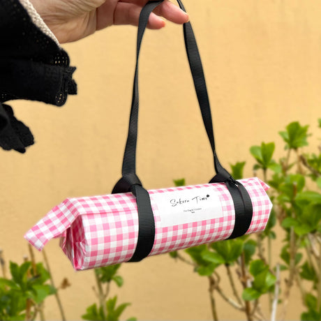 屋外で手に持った桜クッキーのギフトパッケージ｜iico
